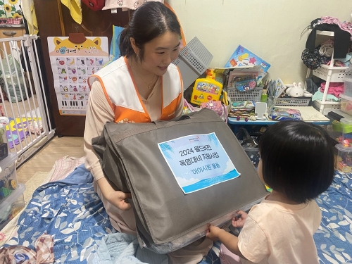 월드비전 직원(왼쪽)이 경기도 성남시에 위치한 한 에너지 빈곤가정을 방문해 냉방용품을 전달하고 있다. (사진=월드비전 제공)