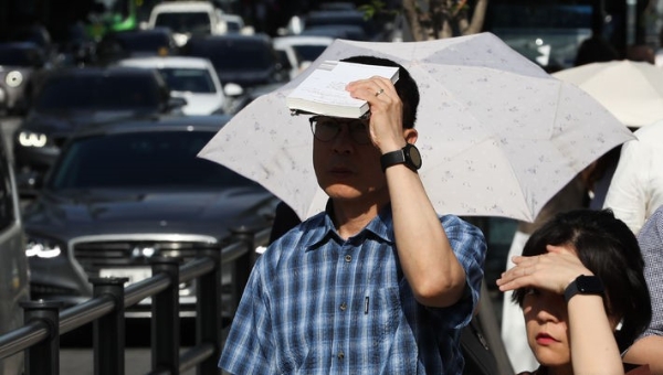 장마기간이 끝나고 이른아침부터 무더운 날씨를 보인 27일 오전 서울 종로구 세종대로 사거리에서 시민들이 발걸음을 재촉하고 있다.
