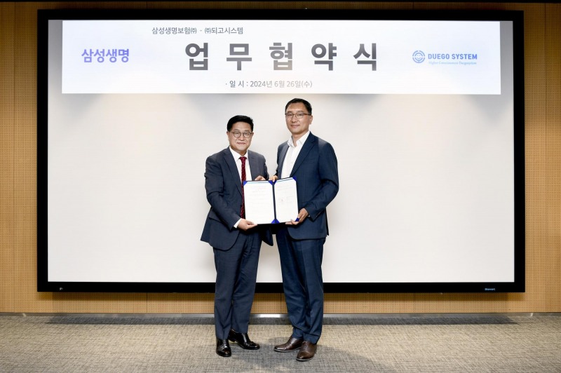 사진: 장승호 삼성생명 단장(왼쪽)과 김용필 되고시스템 대표가 업무협약을 맺은 직후 기념촬영을 하고 있다.