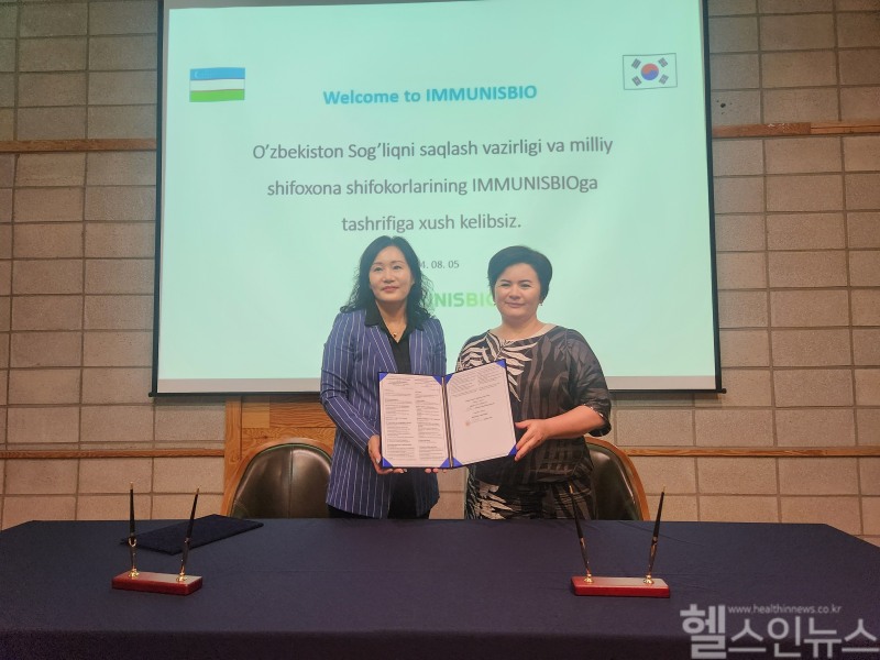 보건부 국장압둘라예바 무앗타르크혼 일레소브나(오른쪽)와 이뮤니스바이오 강정화 대표(왼쪽)가 MOU에 서명 후 기념 촬영하고 있다. (이뮤니스바이오 제공)