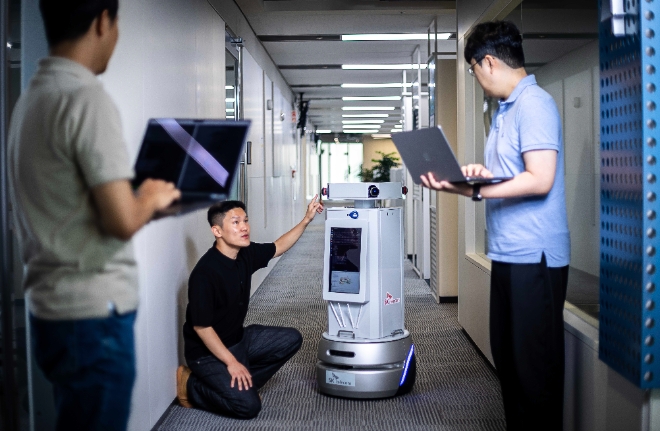 SK텔레콤은 자사의 텔코 에지 AI(Telco Edge AI) 인프라를 기반으로 한 자율주행 로봇 기술 실증을 성공적으로 마쳤다고 7일 밝혔다.사진은 판교사옥에서 연구 중인 SK텔레콤 연구원들의 모습
