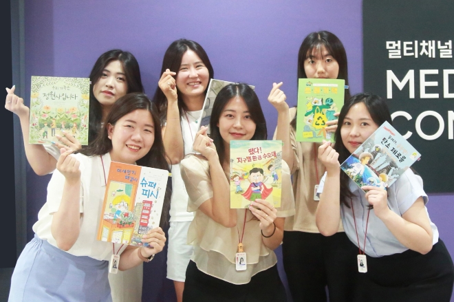 롯데홈쇼핑은 시각장애 아동을 위한 오디오북 제작을 위해 사내 임직원들의 목소리 재능기부로 낭독봉사 프로그램을 진행했습니다. 참여 직원들이 단체사진을 촬영하고 있는 모습.