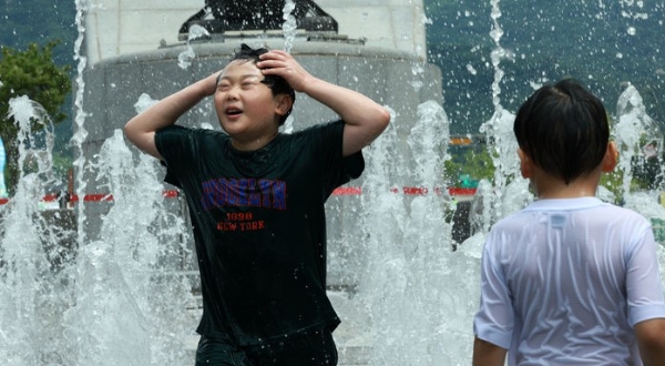 장마가 끝나고 무더운 날씨가 이어지는 지난달 31일 서울 종로구 광화문광장 분수대에서 어린이들이 물놀이를 하며 더위를 식히고 있다.