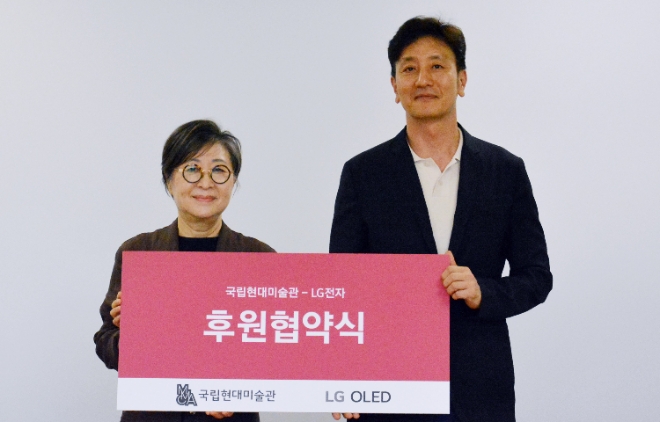LG전자는 최근 국립현대미술관과 ‘MMCA X LG OLED 시리즈’ 전시에 대한 후원 협약을 체결했다고 12일 밝혔다. 사진은 (좌측부터)국립현대미술관 김성희 관장과 LG전자 오승진 한국HE/BS마케팅담당이 기념촬영을 하는 모습. (사진 = LG전자 제공)