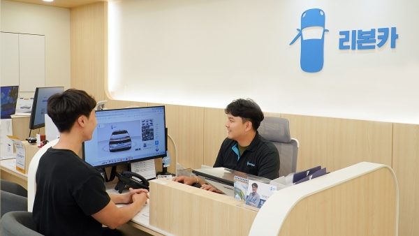 리본카 부산지점에서 고객이 중고차 전문 세일즈매니저에게 상담을 받고 있다.(사진제공=리본카)