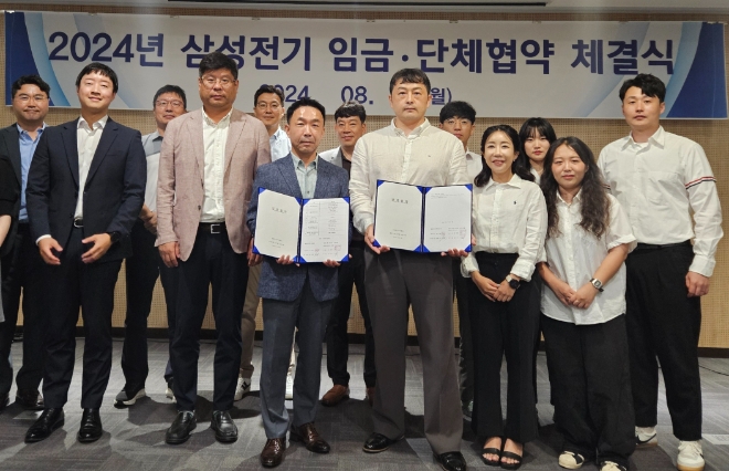 12일 삼성전기 '2024년 임금협약 체결식'에 참석한 박봉수 People팀장(부사장, 앞줄 왼쪽 세번째)와 신훈식 존중노종조합지부장(앞줄 왼쪽 네번째)가 기념사진을 촬영하고 있다.