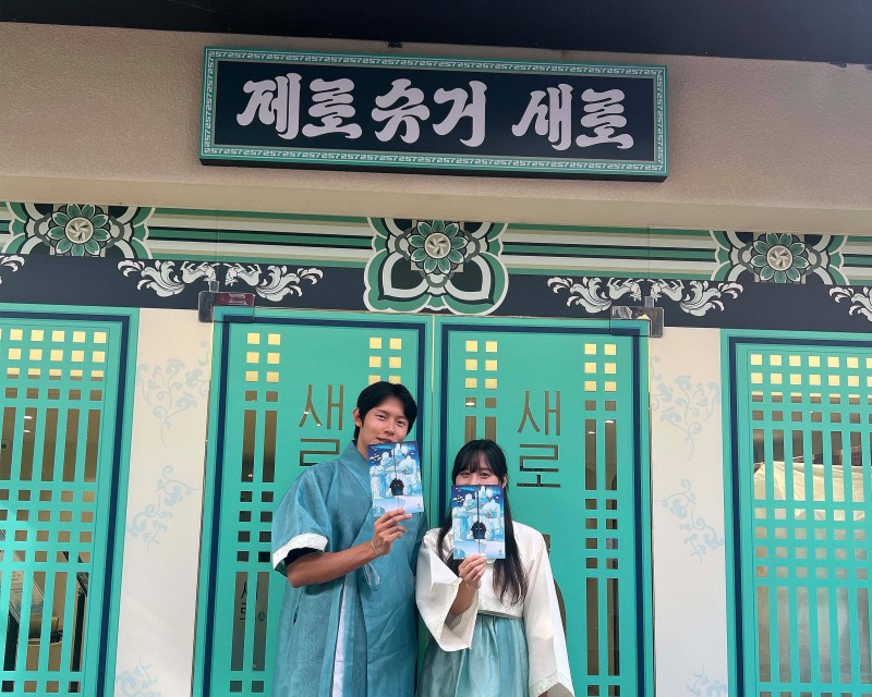 관람객이 팝업스토어 안내소 입구에서 안내 책자를 들고있는 모습