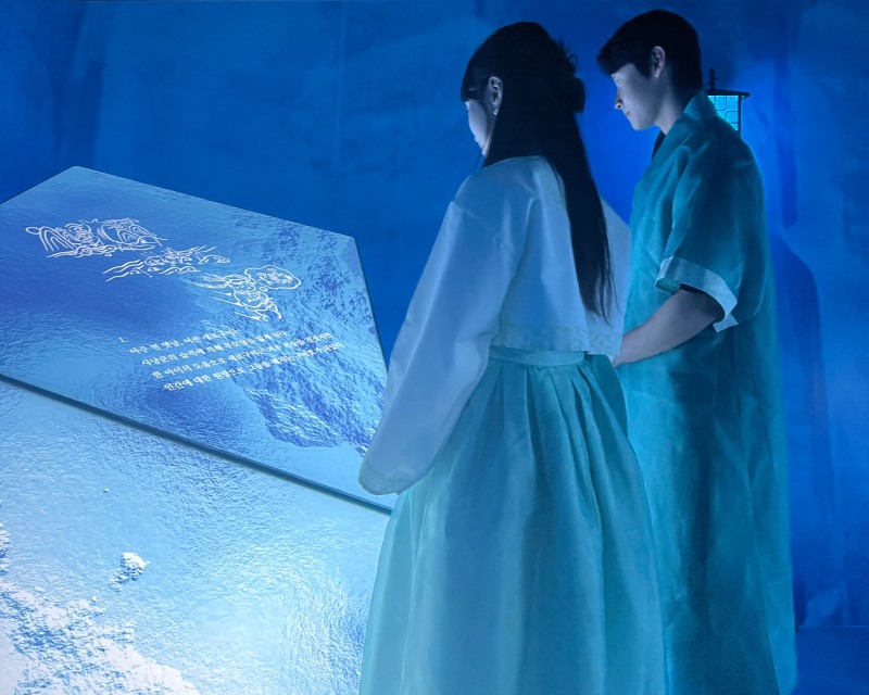 관람객이 '얼음 동굴 벽화'에서 새로구미의 이야기를 알아보고 있는 모습