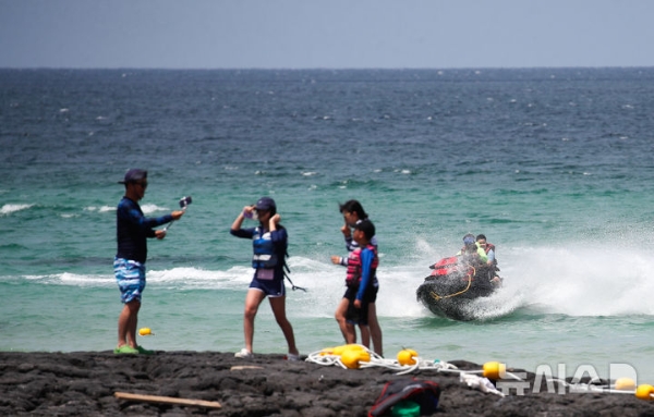 전국 대부분 지역에 폭염특보가 발효 중인 13일 오후 제주시 한림읍 협재해수욕장을 찾은 관광객들이 시원한 바닷물에 몸을 담그며 한낮 더위를 식히고 있다.