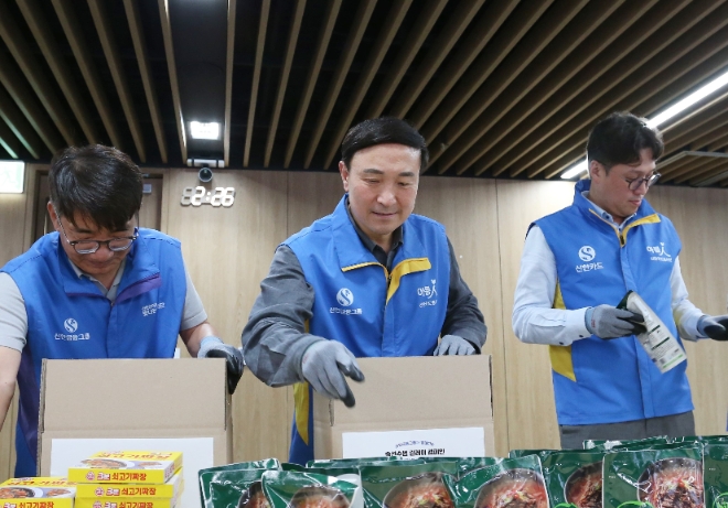 문동권 신한카드 사장(가운데)이 이영종 신한라이프 사장(왼쪽), 강병관 신한EZ손해보험 대표이사(오른쪽)와 식료품 키트를 제작하고 있다. / 사진=신한카드 제공