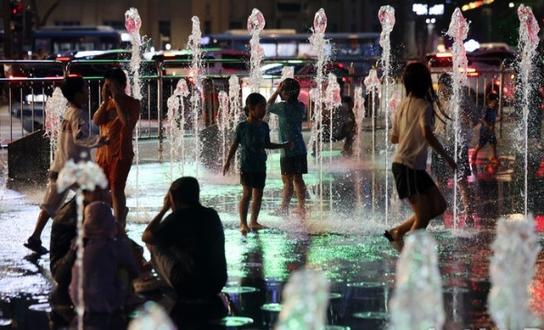 서울에 관측이래 최장 기간 열대야가 지속되고 있는 16일 오후 서울 종로구 광화문광장 분수대에서 아이들이 물놀이를 하며 더위를 식히고 있다.