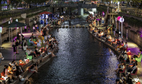 열대야가 이어진 23일 서울 중구 청계천을 찾은 시민들이 휴식을 취하며 더위를 식히고 있다.
