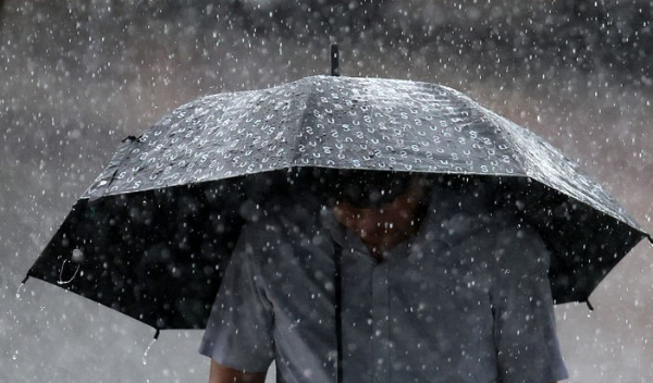 강한 소나기가 내린 5일 오후 대구 동구 동대구역네거리 인근에서 우산을 쓴 한 시민이 발걸음을 재촉하고 있다.