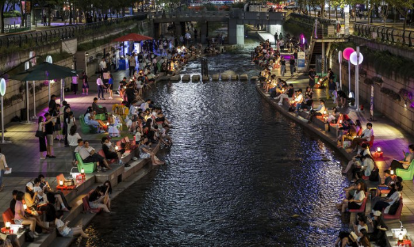 열대야가 이어진 23일 서울 중구 청계천을 찾은 시민들이 휴식을 취하며 더위를 식히고 있다.