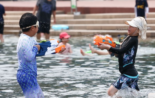 폭염 날씨가 계속되는 전날 서울 영등포구 여의도 한강시민공원 물빛광장에서 어린이들이 더위를 피하기 위해 물놀이를 즐기고 있는 모습.