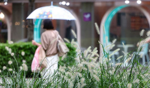 가을비가 내린 5일 서울 마포구 경의선 숲길에서 우산을 쓴 시민들이 발걸음을 옮기고 있다.