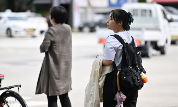 광주지역 일교차가 10도 이상으로 예보된 23일 오전 광주 북구청 사거리에서 한 시민이 겉옷을 챙긴 채 횡단보도 신호를 기다리고 있다.