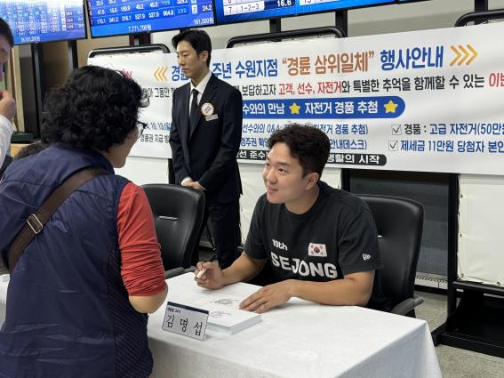 경륜경정총괄본부 수원사업소에서 김명섭 선수가 고객과 소통하며 사인을 해주고 있다.