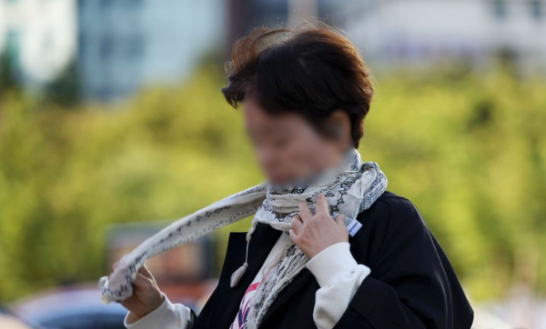 서울 아침 최저기온이 10도 가량 뚝 떨어지며 쌀쌀한 날씨를 보인 지난 2일 오전 서울 종로구 광화문 네거리에서 한 시민이 스카프를 두르며 출근길 발걸음을 재촉하고 있다.