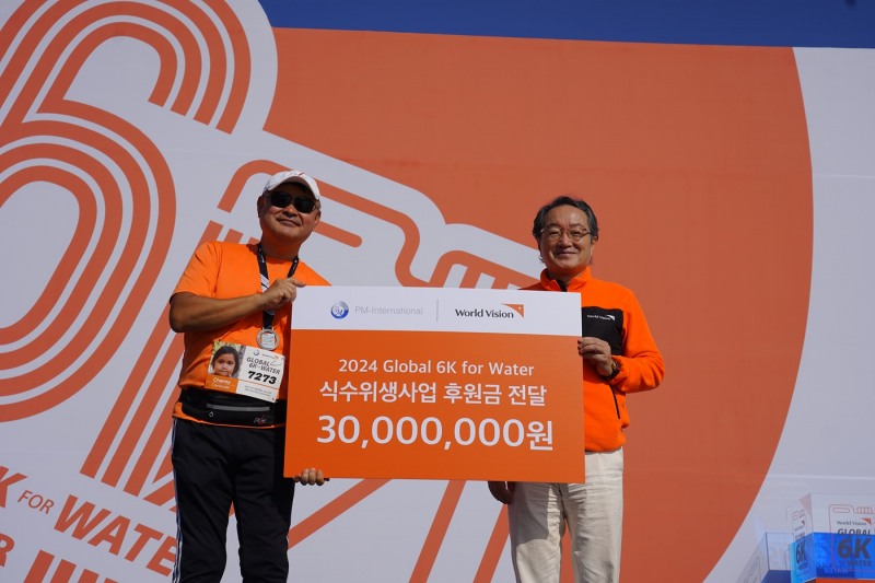 지난 12일 일산 호수공원에서 열린 ‘2024 글로벌 6K 포 워터 러닝’ 행사에서 조명환 월드비전 회장이 오상준 피엠인터내셔널코리아 대표로부터 후원금을 전달받고 기념촬영을 하고 있다. (사진=월드비전 제공)