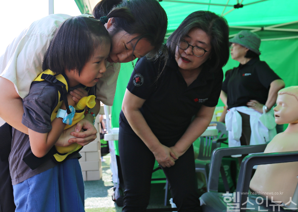 대한적십자사 응급처치 무료 강습 부스를 찾은 시민이 어린이 교보재를 활용해 자녀 기도 폐쇄 시 대처법을 실습해 보고 있다. (대한적십자사 서울특별시지사 제공)