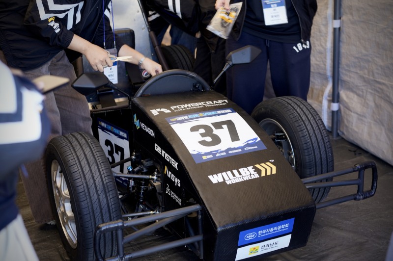 형지엘리트의 워크웨어 브랜드 ‘월비워크웨어’가 ‘2024 대학생 스마트 e-모빌리티 경진대회’에 출전한 이화여자대학교 자작차 동아리 ‘이레이서’에 단체복을 후원했다. 사진은 윌비워크웨어 로고를 부착하고 대회에 나선 이레이서의 자작차 모습