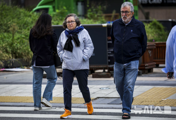 쌀쌀한 날씨를 보인 지난 21일 서울 종로구 광화문네거리에서 몸을 웅크린 시민들이 이동하고 있다