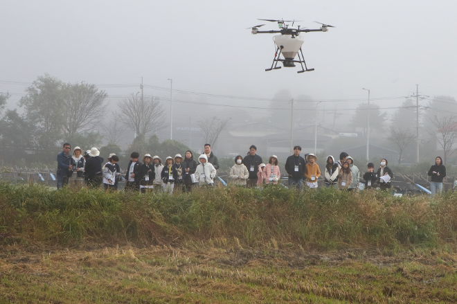 KT는 24일 경기도 파주시 군내면 비무장지대(DMZ)에서 생태계 보호 및 보전을 위한 ‘KT DMZ 생태보전단’ 활동을 성황리에 마쳤다고 밝혔다. 사진은 KT DMZ 생태보전단 프로그램에 참여한 생태보전단원들이 ‘드론을 활용한 볍씨 뿌리기’를 통해 ‘철새 먹이주기’ 활동을 하는 모습. (사진 = KT 제공)