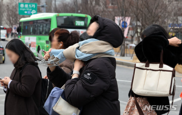 큰 일교차로 쌀쌀한 아침 날씨를 보인 28일 오전 서울 종로구 세종대로 인근에서 한 시민이 보행 신호를 기다리며 목도리를 매고 있다.