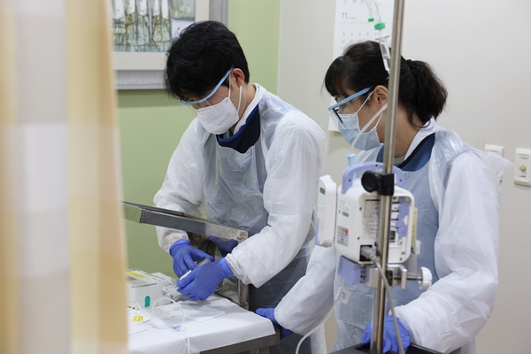 서울아산병원 핵의학과 이동윤 교수와 유선희 전담간호사가 환자에게 플루빅토 약제를 투여하고 있다. (서울아산병원 제공)