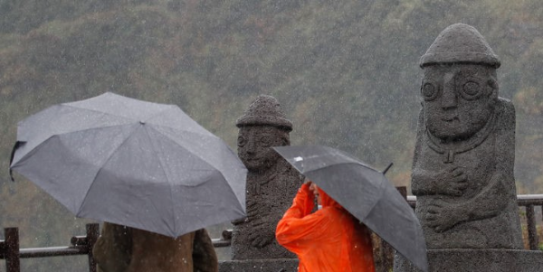 제21호 태풍 '콩레이'의 간접영향으로 많은 비가 내리는 지난 1일 오전 제주 서귀포시 대정읍 송악산 둘레길에서 우산을 쓴 관광객들이 발걸음을 재촉하고 있다.