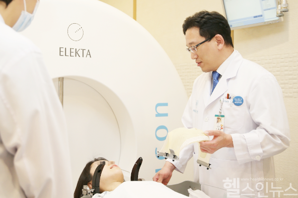 서울아산병원 신경외과 김영훈 교수(우)가 하부 뇌 신경초종 환자에게 감마나이프 수술 전 치료 과정을 설명하고 있다. (서울아산병원 제공)