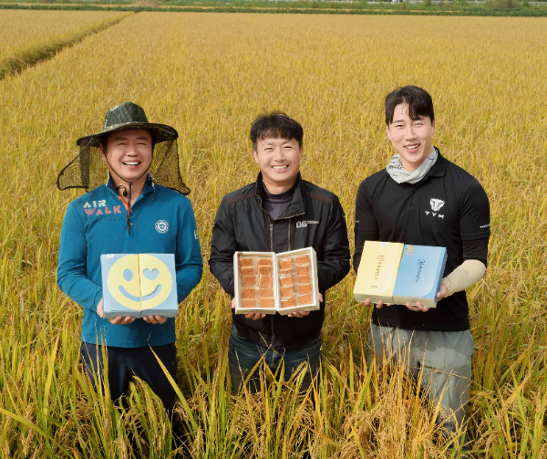 경기도 평택시에 위치한 가루쌀 농가에서 농업인들이 가루쌀을 원료로 활용한 파리바게뜨의 샌드쿠키를 들고 기념 촬영을 하고 있다.