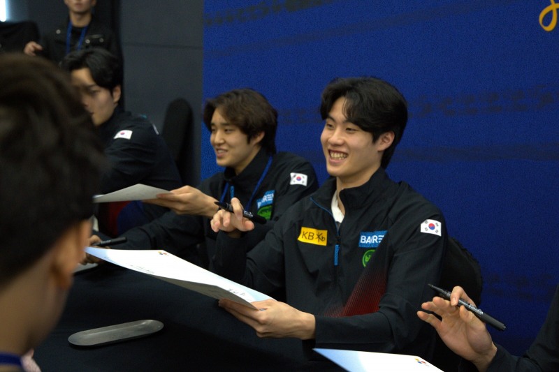 CJ 주최 ‘Locker Room with TEAMCJ’ 행사에서 유망주에게 사인을 해주는 황선우(오른쪽)와 김우민(왼쪽)