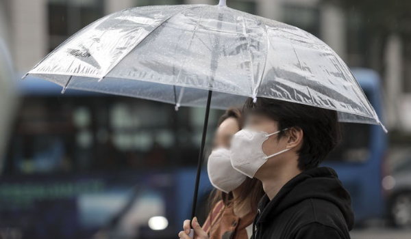 비가 내린 21일 서울 종로구 세종대로 인근에서 우산과 마스크를 쓴 시민들이 신호를 기다리고 있다.