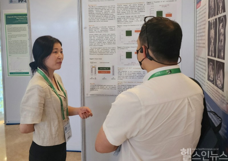 유정민 대웅제약 임상연구팀원(왼쪽)이 해외 의료진에 우루사 임상4상 관련 포스터를 소개하고 있다. (대웅제약 제공)