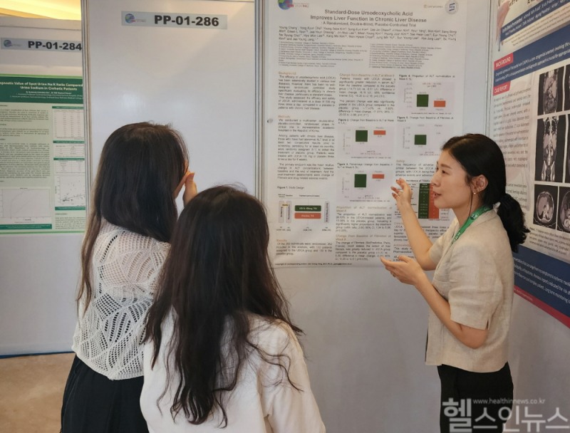 유정민 대웅제약 임상연구팀원(오른쪽)이 우루사 임상4상 관련 포스터를 소개하고 있다. (대웅제약 제공)