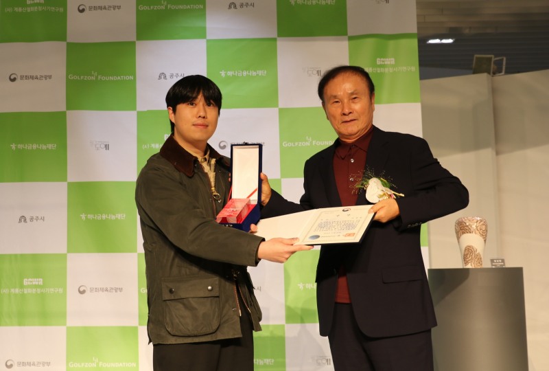 27일 골프존조이마루에서 열린 ‘제4회 철화분청사기 산업이 되다’ 시상식에서 김영찬 골프존문화재단 이사장(오른쪽)이 대상을 수상한 이문현 도예가에게 상장과 트로피를 수여하고 기념촬영을 하고 있다.