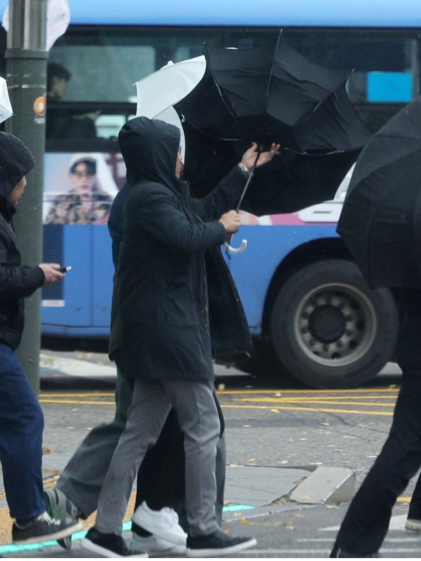 비가 내리고 찬 바람이 불고 있는 지난달 26일 서울 중구의 한 거리에서 시민들이 우산을 쓰고 지나가고 있다.