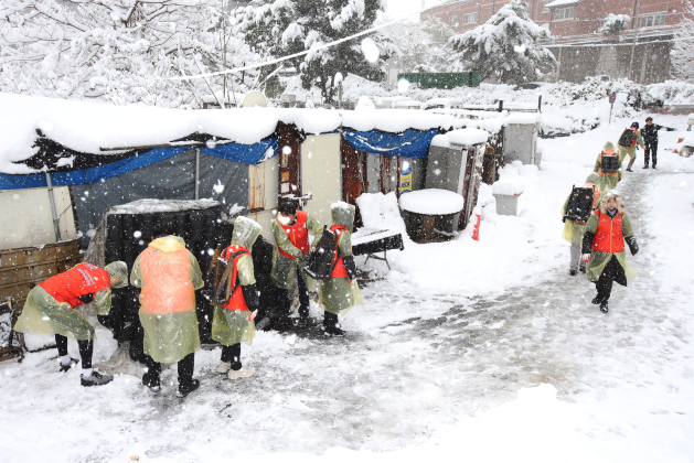 경륜경정총괄본부 임직원들이 차량 진입이 어려운 가구에 지게로 연탄을 지어 나르고 있다.