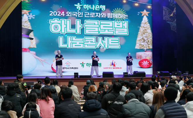 하나은행은 지난 15일 외국인근로자 및 다문화가정 약 1000명을 서울 잠실 롯데월드 어드벤처로 초청해 연말 맞이 ‘2024 하나글로벌나눔콘서트’를 개최했다고 16일 밝혔다. 사진은 이날 행사에 참여한 외국인근로자 및 다문화가정 구성원들이 우리나라 전통 의상과 탈을 쓰고 국악에 맞춰 비보잉을 하는 '에스플라바(S-FLAVA)'의 댄스 무대를 관람하고 있는 모습. (사진 = 하나은행 제공)