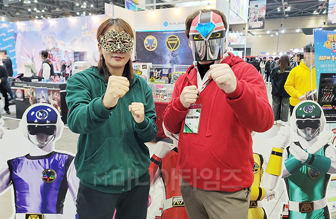 AGF 2024 엑스플래닛 부스 앞에서 자세를 취해주고 있는 컴투스플랫폼 이은표 팀장(오른쪽)과 강민성 과장. 마스크를 보면 알지만 슈퍼전대의 팬이다. 현장에서는 사진을 촬영한다고 하니 자연스럽게 가면부터 썼다. 사진 촬영 : 마니아타임즈 이동근 기자