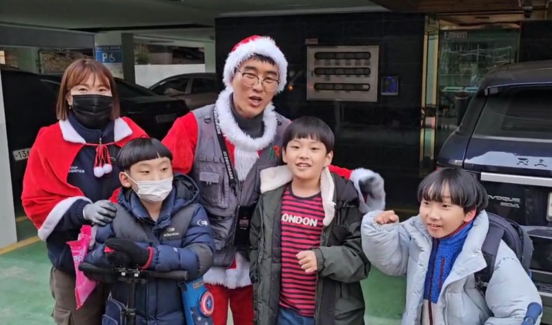 산타 복장을 한 HR그룹 배송 팀원들이 배송 중 만난 아이들과 즐겁게 사진을 찍고 있다./사진=HR그룹 미디어팀