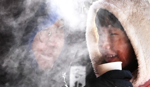 찬바람이 불며 추운 날씨를 보인 지난해 12월26일 경기도 용인시 한국민속촌을 찾은 한 부녀가 따뜻한 어묵 국물을 마시면서 몸을 녹이고 있다.