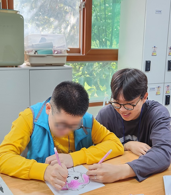 장애인종합복지관 ‘아트클래스’에 참여해 함께 그림을 그리고 있는 서울대학교 학생사회공헌단 배프팀 팀원