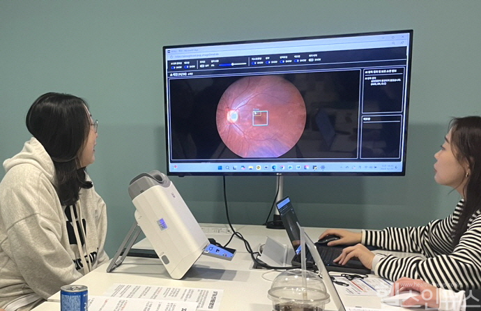 대웅제약 임직원(왼쪽)이 AI 실명질환 진단 보조 솔루션 위스키(WISKY)와 안저카메라 옵티나 제네시스(OPTiNA Genesis)를 이용해 3대 실명질환 검사를 받은 후, AI 판독 결과를 확인하고 있다. (대웅제약 제공)