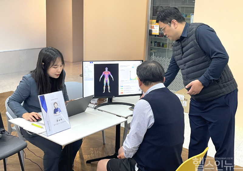 대웅제약 임직원(가운데)이 AI 근감소증 진단기기를 이용해 검사를 받은 후, 근감소증 유병 여부를 확인하고 있다. (대웅제약 제공)