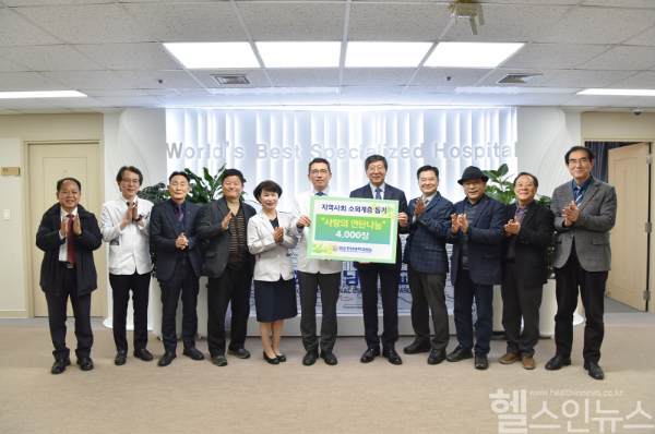 민정준 화순전남대병원장(왼쪽에서 여섯 번째)이 광주기독교단협의회 대표회장 이종석 목사(오른쪽에서 다섯 번째)에게 사랑의 연탄나누기 캠페인 후원금을 전달하고 참석자들과 기념 촬영하고 있다. (화순전남대병원 제공)