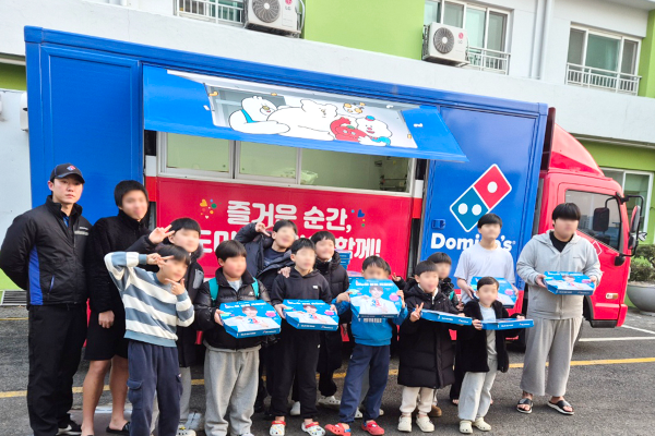 도미노피자의 이동식 피자 트럭 '파티카' 앞에서 피자 나눔 활동 기념사진을 촬영하고 있다(희망브리지 제공)