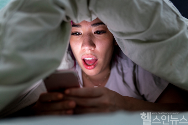 자기 전 불을 끄고 어두운 공간에서 스마트폰을 하는 습관을 개선하지 않는다면 실명을 초래할 수 있는 급성폐쇄성녹내장이 유발될 수 있어 주의가 필요하다. (클립아트코리아)